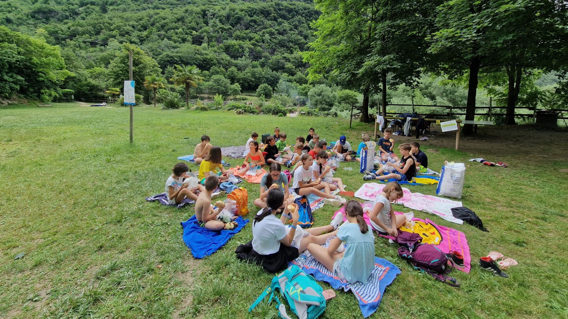Bambini del camp riuniti in cerchio sul prato durante un gioco di gruppo