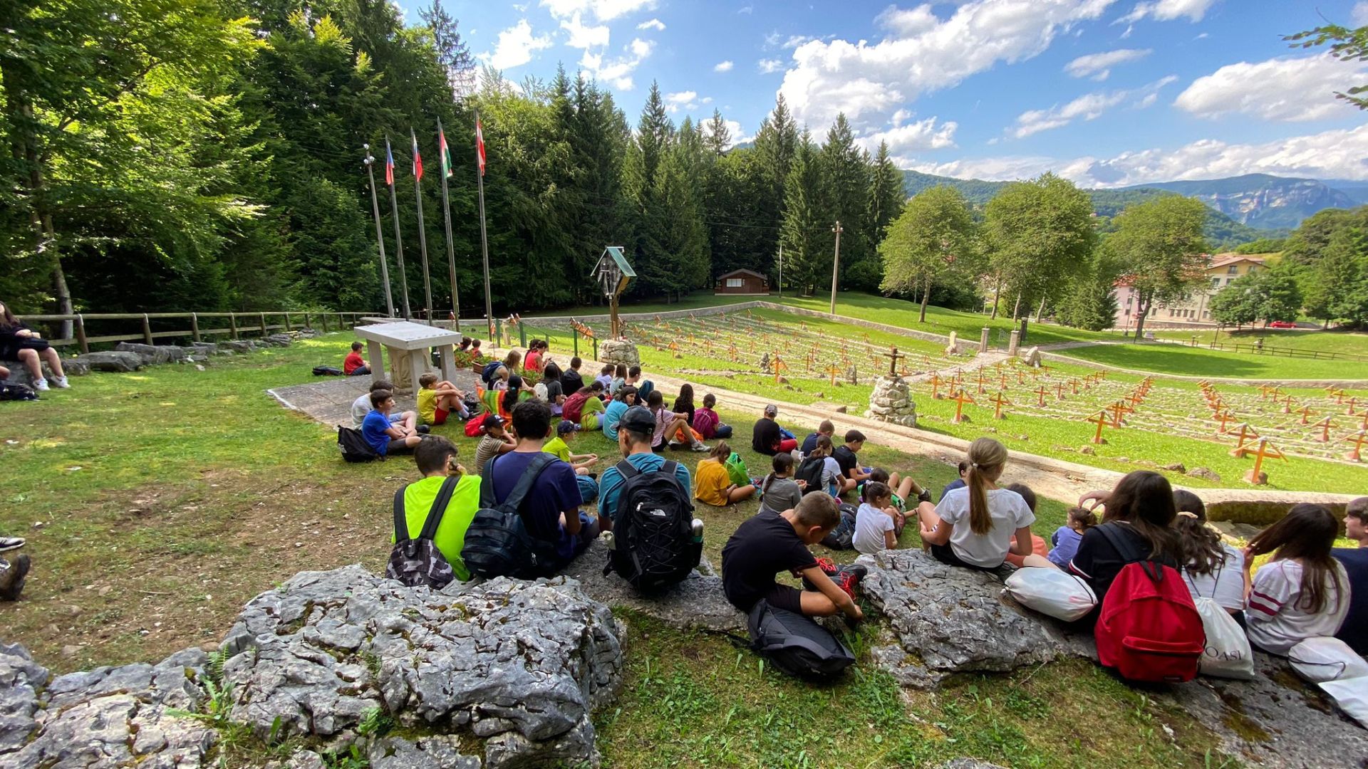 Ragazzi del camp seduti in cerchio nel prato per un pic-nic
